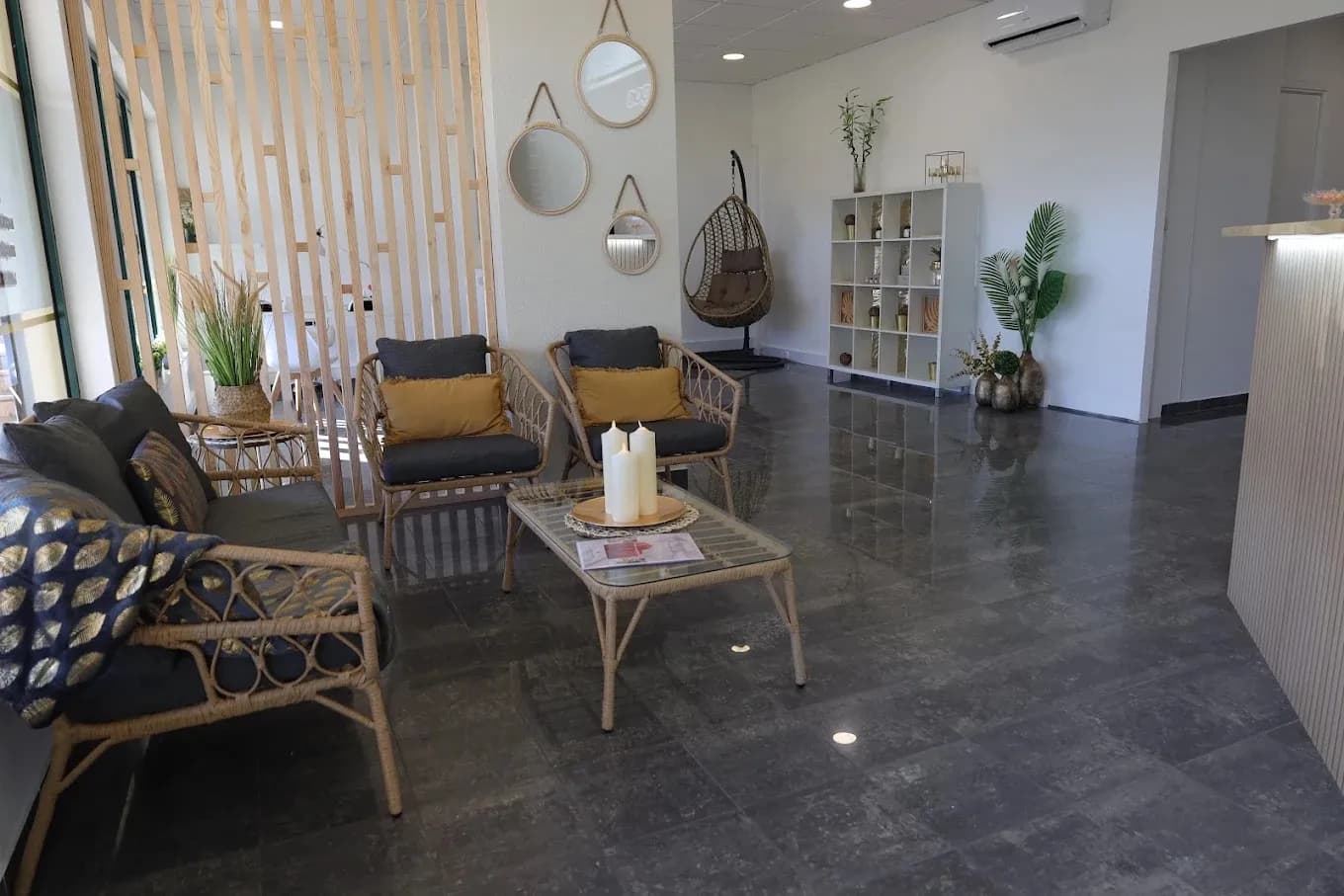 Sala de espera com cadeirões de vime e almofadas douradas